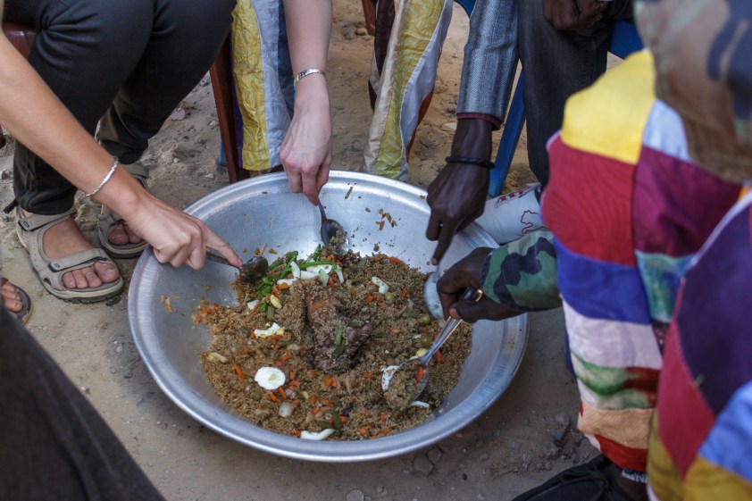Assis sur une chaise ou sur une natte, le repas sénégalais se mange en famille autour du même bol.